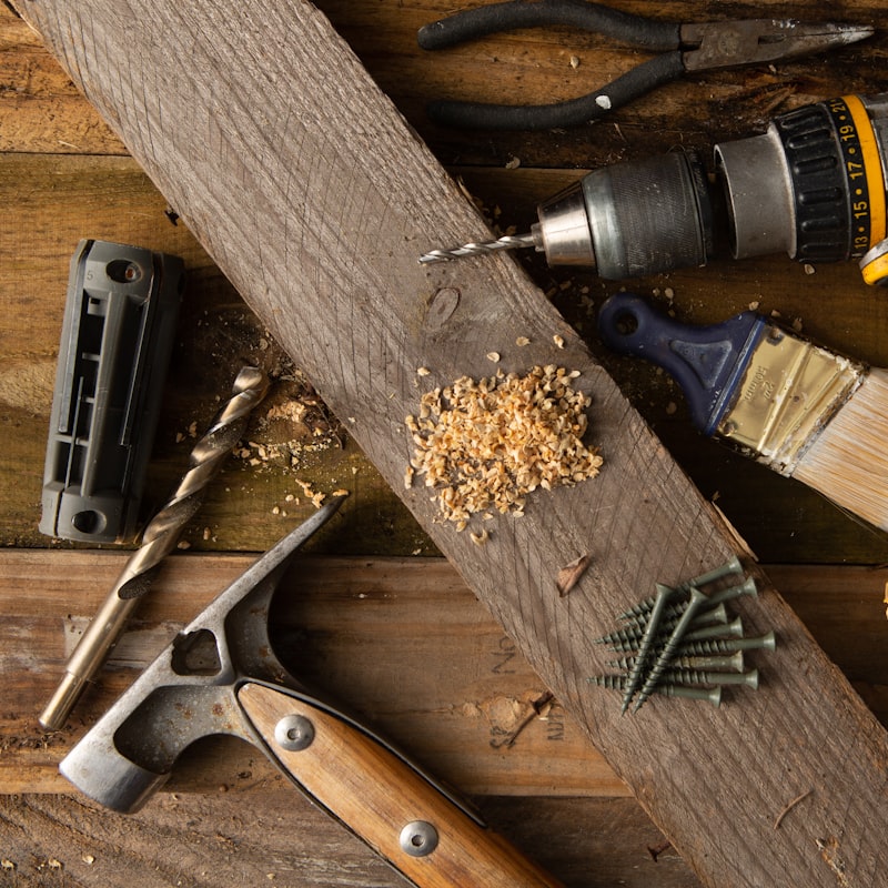 Drill, hammer, chisels and screws on timber